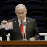 Video: Netanyahu heckled while showing photos of Bibas family